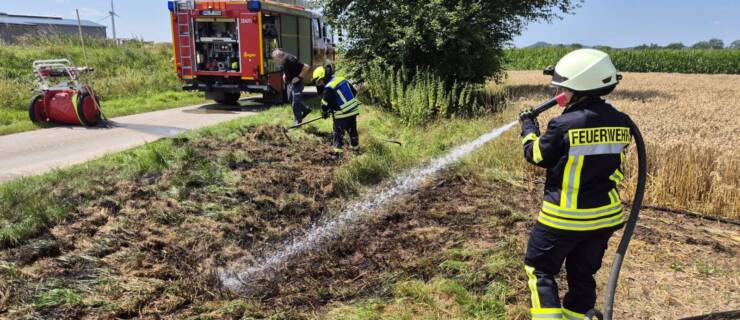 Flächenbrand an Straßenrand und Getreidefeld
